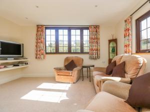 a living room with two couches and a tv at Carne Mill in Helston