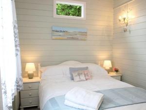 a bedroom with a white bed with two lamps at Daisy Lodge in Looe +18 photos