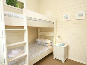 a small bedroom with bunk beds and a desk at Sam's Cabin in Looe +17 photos