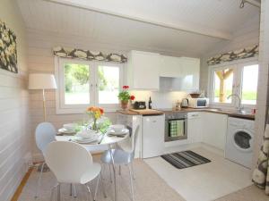 a kitchen with a table and chairs in a kitchen at Daisy Lodge in Looe