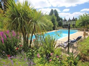a garden with a swimming pool and some plants at Sam's Cabin in Looe