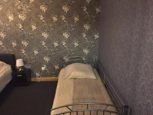 a small bed in a bedroom with wallpaper at Viktor in Pirmasens +1 photo