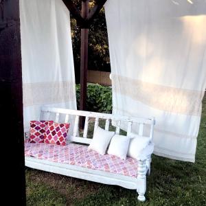 Cama blanca con almohadas en la hierba en B&B La Tasgia, en Aggius