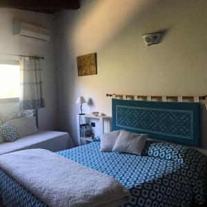 a bedroom with a bed with a blue head board at B&B La Tasgia in Aggius
