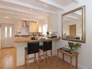 a kitchen with a counter with chairs and a mirror at Five Degrees West in St Just