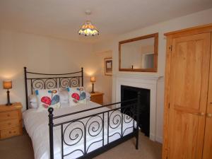 a bedroom with a black bed and a fireplace at Jordan House in Boscastle