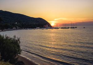a sunset over a body of water with boats at Torre di Baratti Bio Resort in Populonia