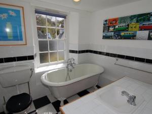 a bathroom with a tub and a toilet and a sink at Jordan House in Boscastle