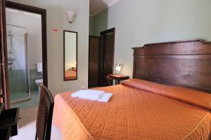 
a hotel room with a bed and a dresser at Dimora Relais Excelsa in Gallipoli
