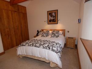 a bedroom with a bed with a black and white comforter at Hideaway in Tintagel