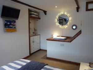 a bedroom with a bed and a mirror on the wall at The Keep Pot in Port Isaac