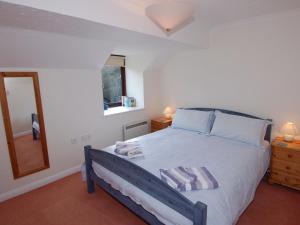 a bedroom with a large bed and a mirror at Pine Cottage in Falmouth +10 photos