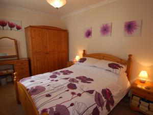 a bedroom with a bed and a dresser and a mirror at Trevillas in St Austell