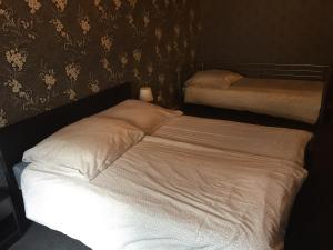 2 camas en un dormitorio con sábanas blancas en Viktor, en Pirmasens