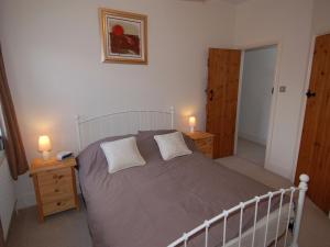 um quarto com uma cama grande e 2 candeeiros nas mesas em The Barn em Camelford