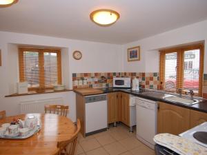 a kitchen with a wooden table and a kitchen with a table and a dining room at The Old Cider Barn in Wells