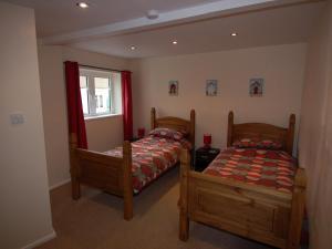 a bedroom with two beds and a window at Brookfield Lodge in Burstock