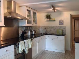 Una cocina con gabinetes blancos y encimeras negras. en Lakeside, en Millbrook