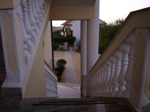 eine Treppe, die zu einem Haus mit weißem Geländer führt in der Unterkunft Villa Jukic in Murter