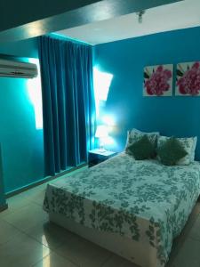 a blue bedroom with a bed and blue walls at Apartamento Aquarel in Boca Chica +18 photos