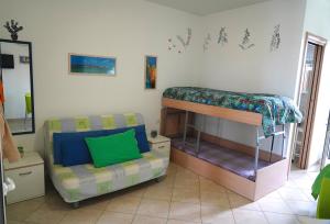 a bedroom with a bunk bed and a couch at Dolly Monolocali in Porto Cesareo