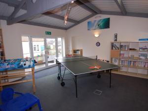 a room with a ping pong table and a bed at Brookfield Lodge in Burstock