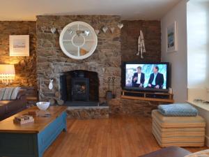 sala de estar con chimenea de piedra y TV en Lakeside, en Millbrook