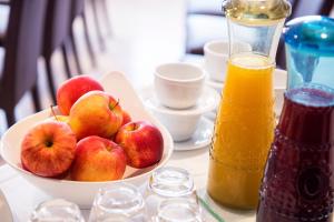 a bowl of apples on a table with a bowl of orange juice at Hotel Isola Sacra Rome Airport in Fiumicino