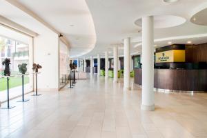 a hallway in a building with columns and a lobby at Hotel Isola Sacra Rome Airport in Fiumicino +37 photos