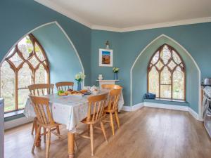 a dining room with blue walls and a table with chairs at Brynkir Tower in Llanfihangel-y-pennant
