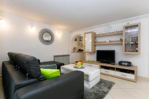 uma sala de estar com um sofá e uma televisão em Apartment Sanja em Malinska