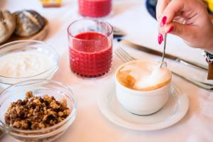 a person is stirring a cup of coffee with a spoon at Hotel Isola Sacra Rome Airport in Fiumicino