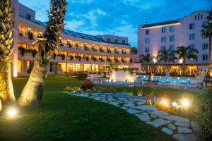 a hotel with a courtyard at night with lights at Hotel Isola Sacra Rome Airport in Fiumicino