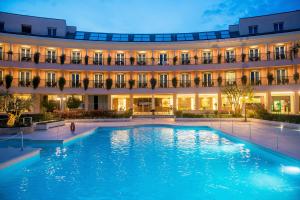 a large swimming pool in front of a building at Hotel Isola Sacra Rome Airport in Fiumicino
