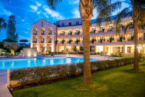 a hotel with a swimming pool at night at Hotel Isola Sacra Rome Airport in Fiumicino