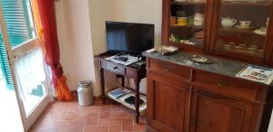 un soggiorno con TV e cassettiera in legno di Casa Violetta a Levanto