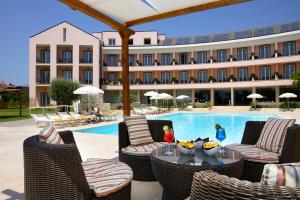 a hotel with a swimming pool and chairs and a table at Hotel Isola Sacra Rome Airport in Fiumicino