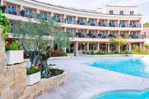 a hotel with a swimming pool in front of a building at Hotel Isola Sacra Rome Airport in Fiumicino