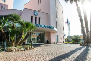 a building with a clock on the side of it at Hotel Isola Sacra Rome Airport in Fiumicino