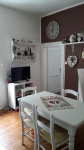 a dining room with a table and chairs and a clock at La Casa di Davide - David Home in Cave del Predil