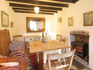 a dining room with a wooden table and a fireplace at Buck Cottage in Pentraeth