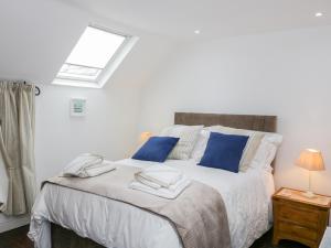 a bedroom with a bed with blue pillows and a window at Hafodty in Conwy