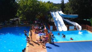 a group of people in a pool at a water park at Camping LE PIGEONNIER in Saint-Crépin-et-Carlucet