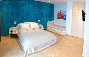 - une chambre avec un lit blanc et un mur bleu dans l'établissement Nautilus Dome, à Fira