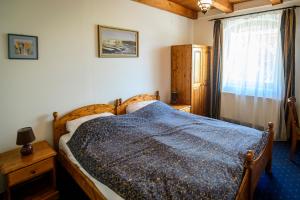 ein Schlafzimmer mit einem Holzbett und einem Fenster in der Unterkunft Tekergő Motel és Étterem in Velence