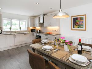 a kitchen with a wooden table and a dining room at Cuckooland in Porthmadog