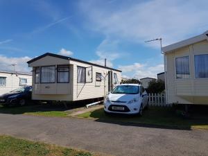 a small car parked in front of a tiny house at 4 Berth with private Garden - 58 Brightholme Holiday Park Brean! in Brean