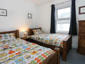 a bedroom with two beds and a window at Gwalia Stores in Beaumaris