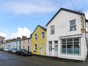 a row of houses on a street with parked cars at Gwalia Stores in Beaumaris