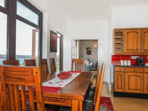 a kitchen and dining room with a table and chairs at Gwylan Uchaf in Y Felinheli